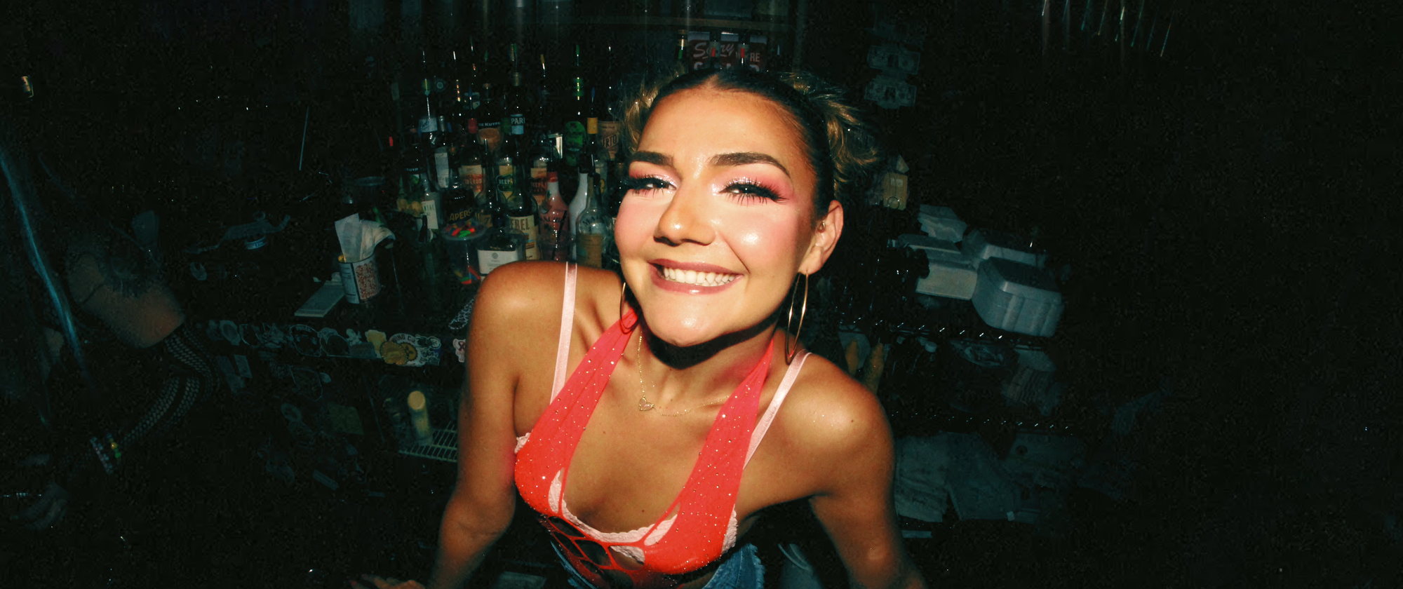 Flash portrait behind the bar at a late-night venue
